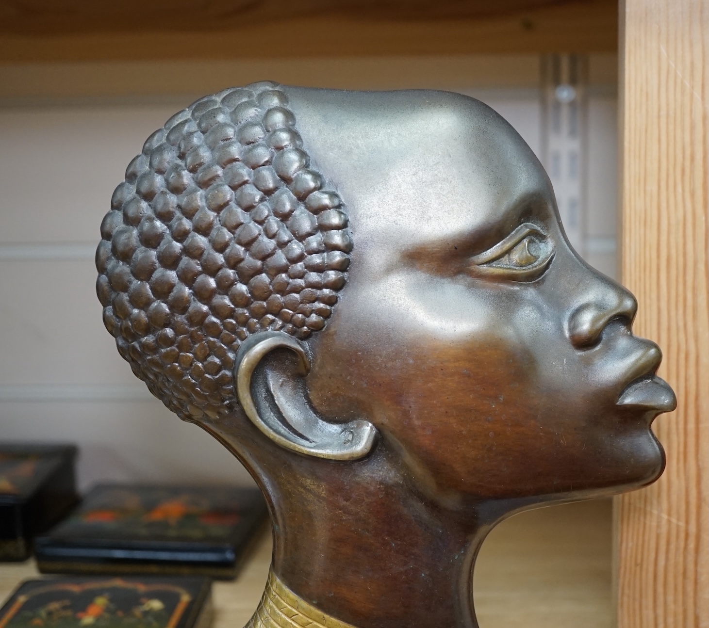 An Art Deco Hagenauer style bronze study of an African lady, stepped marble base, 28cm. Condition - earring missing